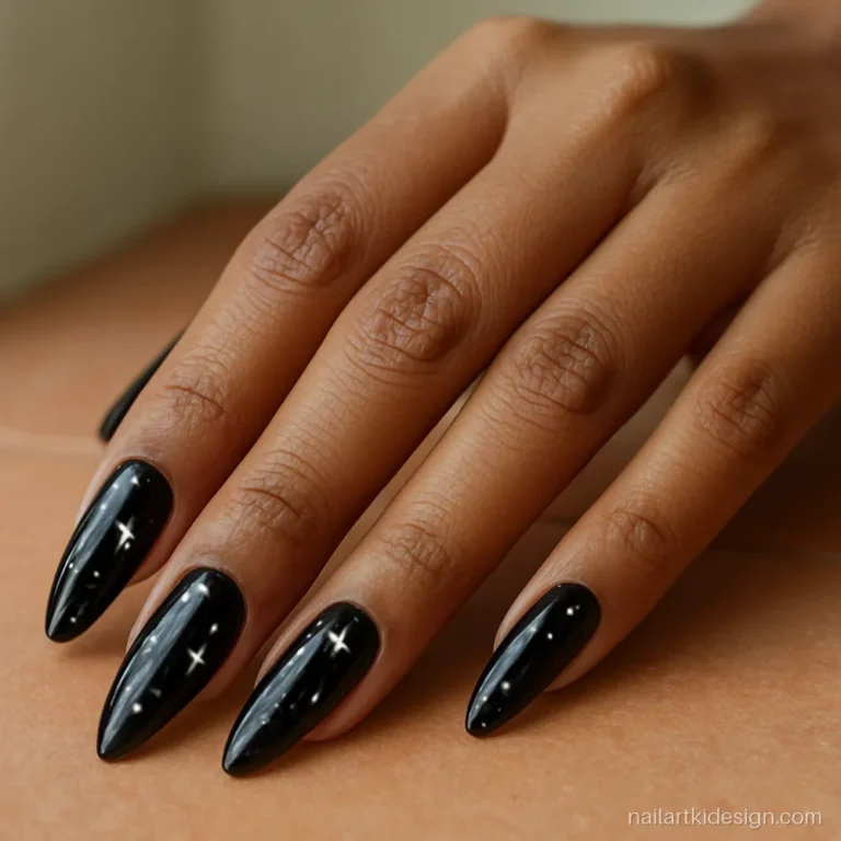 Black nail art with tiny white stars on long almond nails