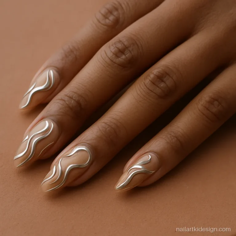 Chrome nail art with raised silver swirls on nude almond nails