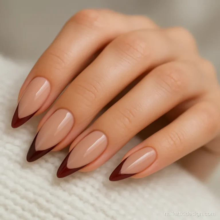 Maroon French tip nail art on long almond nails with a glossy finish