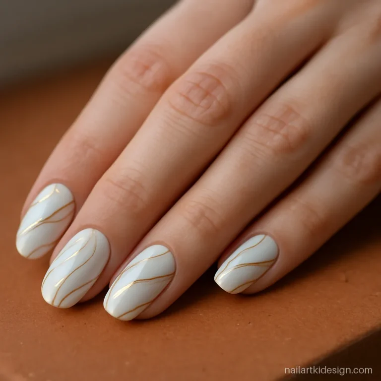White and gold nails with soft gold swirls on medium oval nails