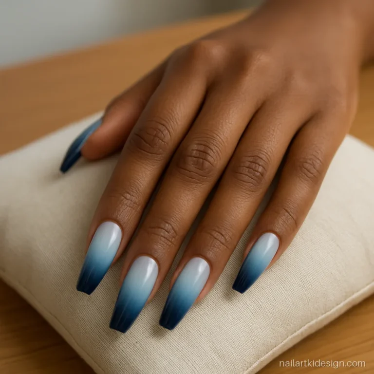 Blue ombre nails fading from navy to white on long coffin nails
