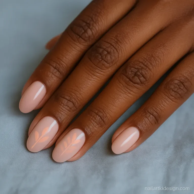 Nude pink nails with small peach leaf art on two accent nails