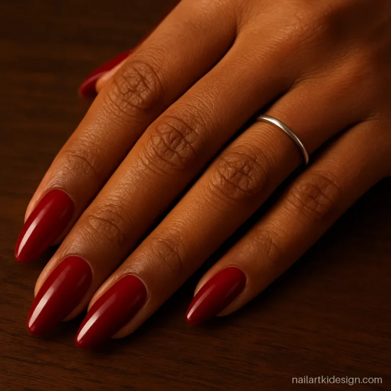 Blood red nail polish on long almond nails with a deep glossy shine