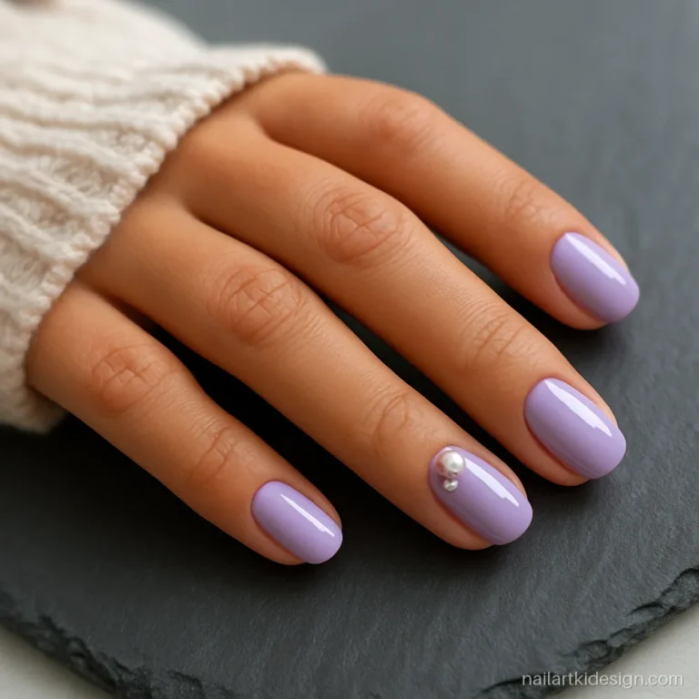 Lavender nails with one pearl and one tiny crystal on the ring finger